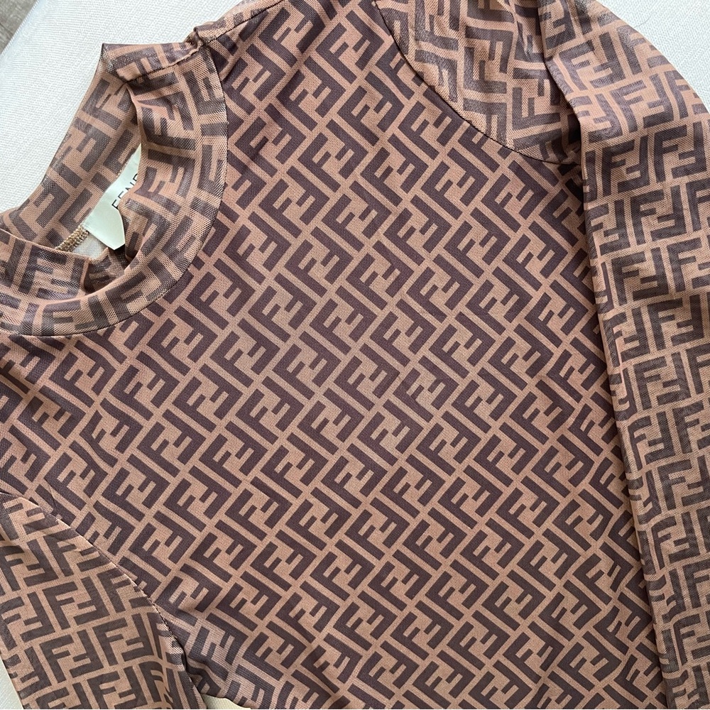 Step into luxury with Fendi’s black and white mesh top—bold, sleek, and iconic.